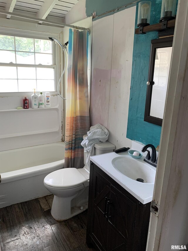 full bathroom with hardwood / wood-style flooring, vanity, shower / bathtub combination with curtain, and toilet