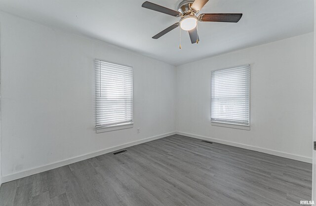 unfurnished room with hardwood / wood-style floors, a wealth of natural light, and ceiling fan