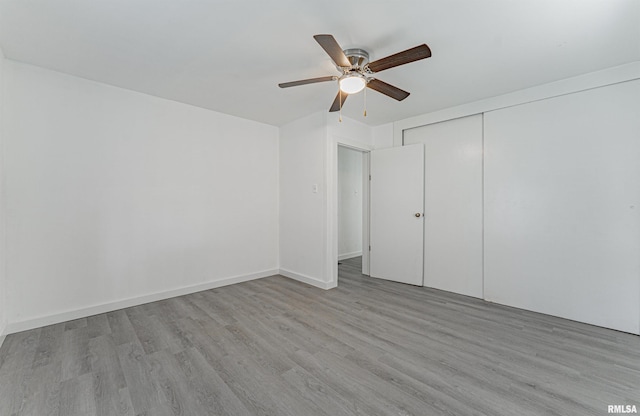 unfurnished bedroom featuring ceiling fan, a closet, and light hardwood / wood-style flooring