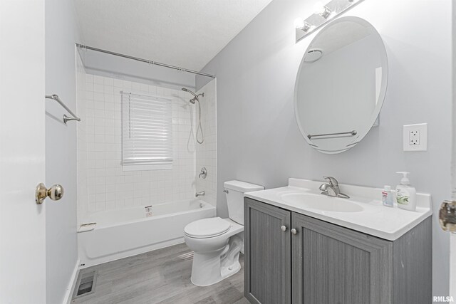 full bathroom with wood-type flooring, toilet, vanity, and tiled shower / bath