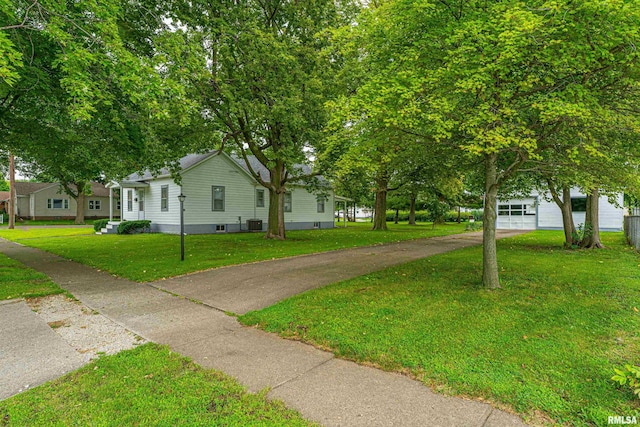 view of front of house with a garage, a front yard, and cooling unit