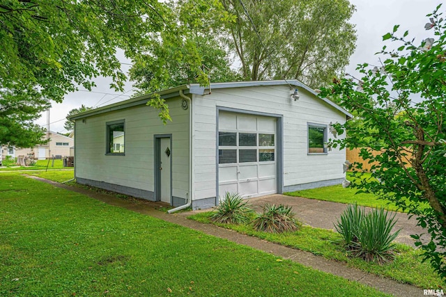 exterior space with a garage and a lawn