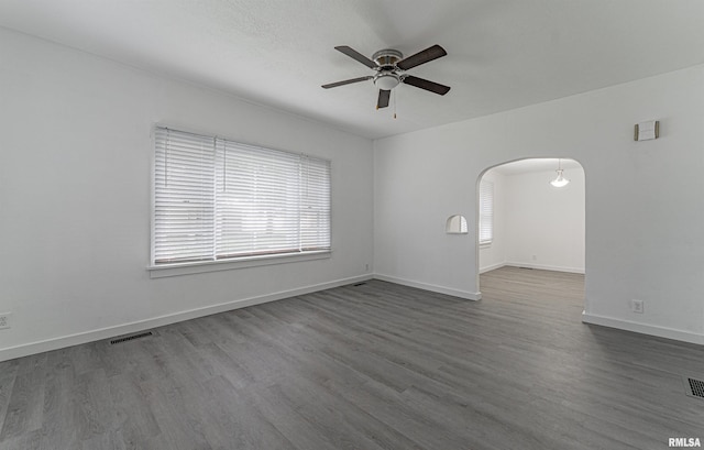 empty room featuring hardwood / wood-style floors, a wealth of natural light, and ceiling fan