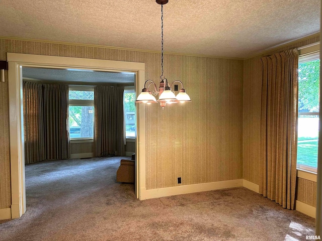 unfurnished dining area with a chandelier, carpet floors, and a textured ceiling