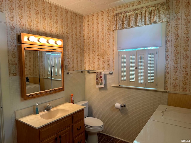 bathroom with vanity, tile patterned flooring, toilet, and washing machine and clothes dryer