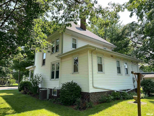 view of side of home featuring a yard and central AC unit