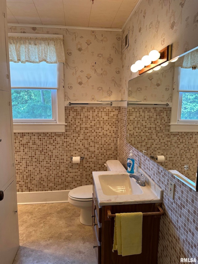 bathroom with concrete floors, tile walls, toilet, and vanity