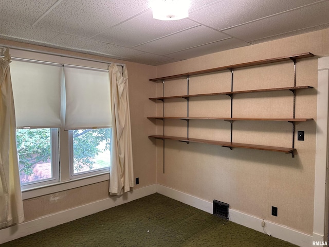212 S Broadway St, Stronghurst, IL 61480 - unfurnished room with baseboards, dark colored carpet, and a paneled ceiling