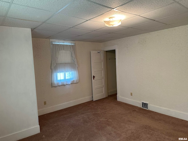 unfurnished room with a paneled ceiling and carpet flooring