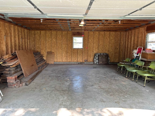 garage featuring a garage door opener and wooden walls