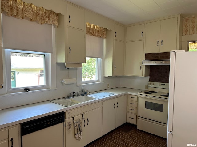 kitchen with sink, dark tile patterned floors, white appliances, and white cabinetry