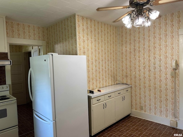 kitchen featuring white cabinetry, ceiling fan, dark tile patterned flooring, and white appliances