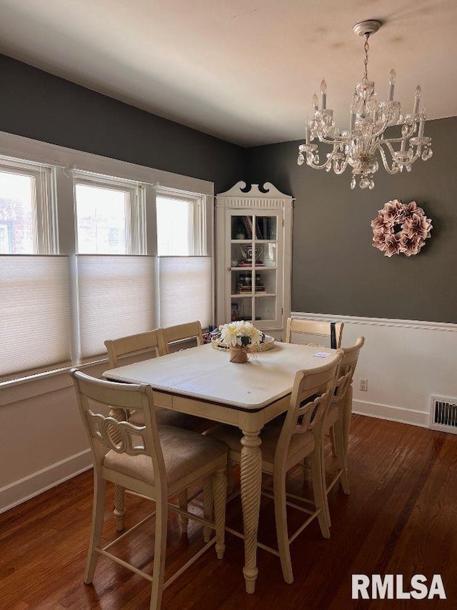 dining area featuring an inviting chandelier and dark hardwood / wood-style flooring