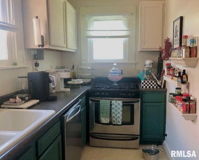 kitchen featuring stainless steel appliances, white cabinets, light tile patterned floors, sink, and green cabinetry