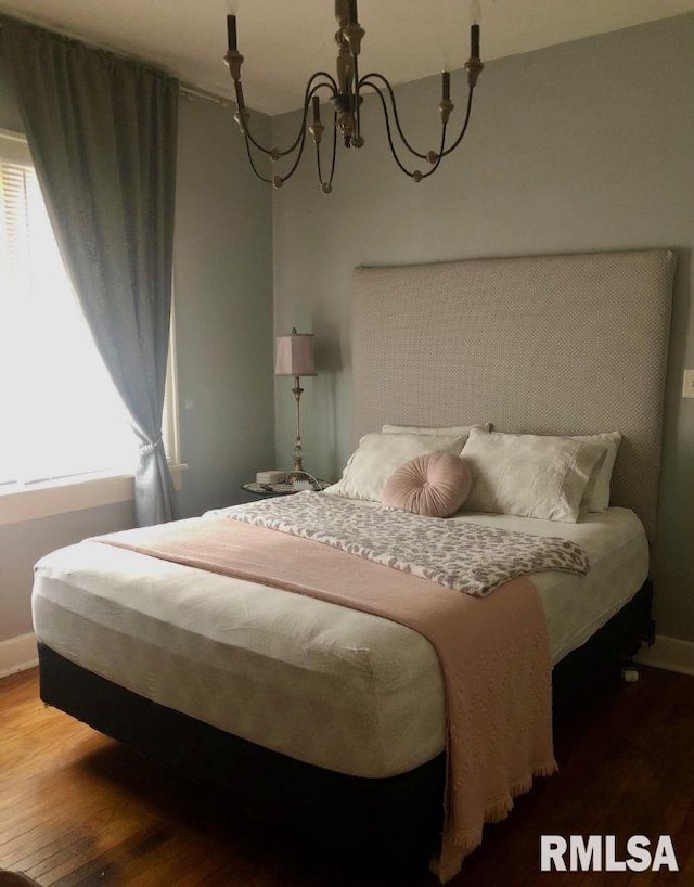 bedroom with an inviting chandelier and hardwood / wood-style floors