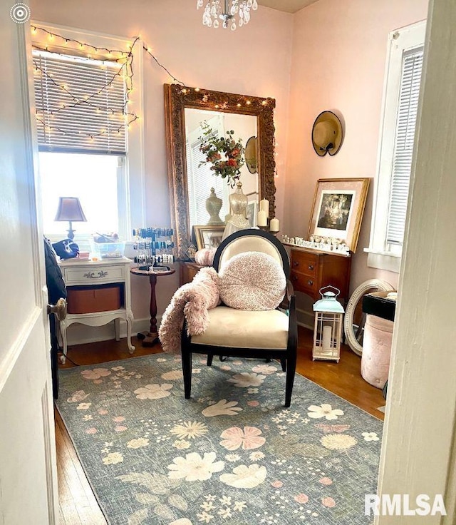 living area featuring an inviting chandelier and hardwood / wood-style flooring