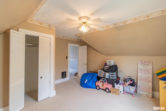 playroom featuring a textured ceiling, light colored carpet, vaulted ceiling, and ceiling fan