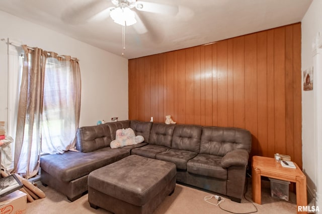 carpeted living room with wood walls and ceiling fan