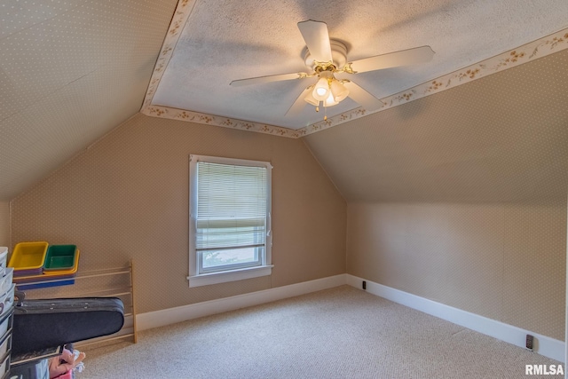 bonus room featuring carpet, a textured ceiling, ceiling fan, and lofted ceiling