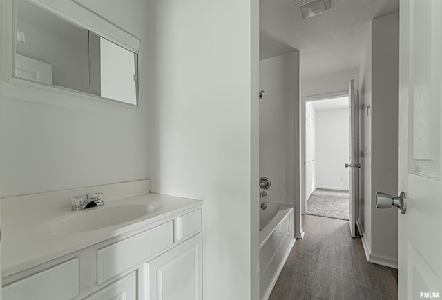 bathroom with vanity, hardwood / wood-style flooring, and shower / bathing tub combination