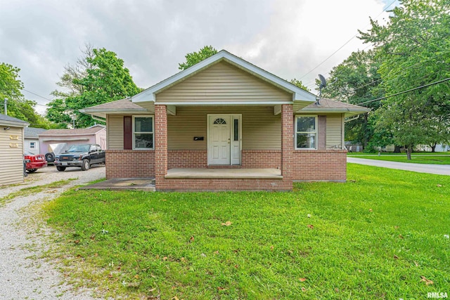 bungalow with covered porch and a front yard