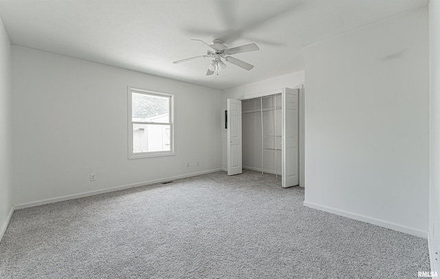 unfurnished bedroom featuring ceiling fan, a closet, and light carpet