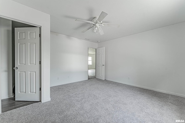 carpeted spare room with ceiling fan