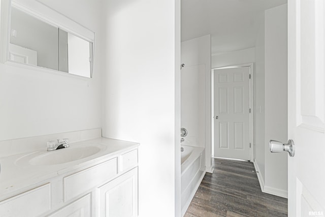 bathroom with shower / washtub combination, hardwood / wood-style floors, and vanity