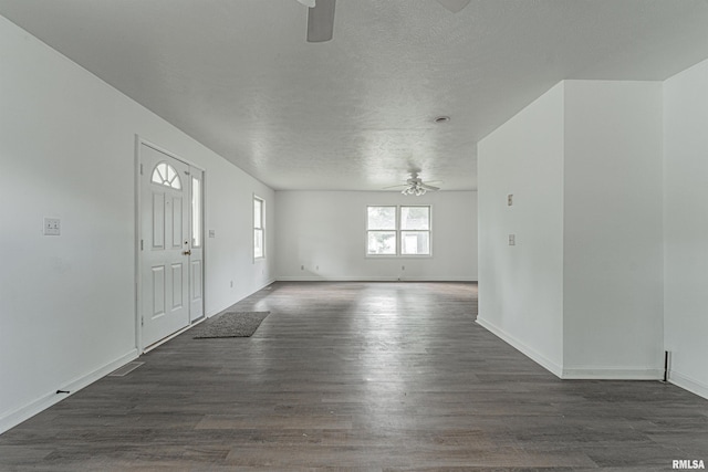 interior space featuring a textured ceiling, dark wood-type flooring, and ceiling fan