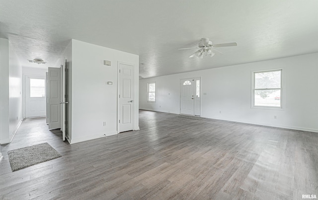 unfurnished living room with wood-type flooring and ceiling fan