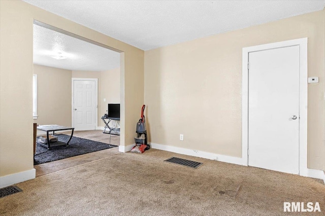 exercise room with light carpet and a textured ceiling