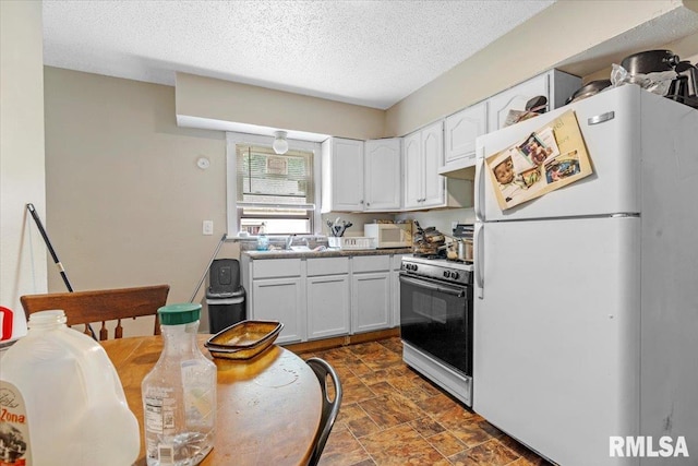 kitchen featuring a textured ceiling, sink, white cabinets, and white appliances