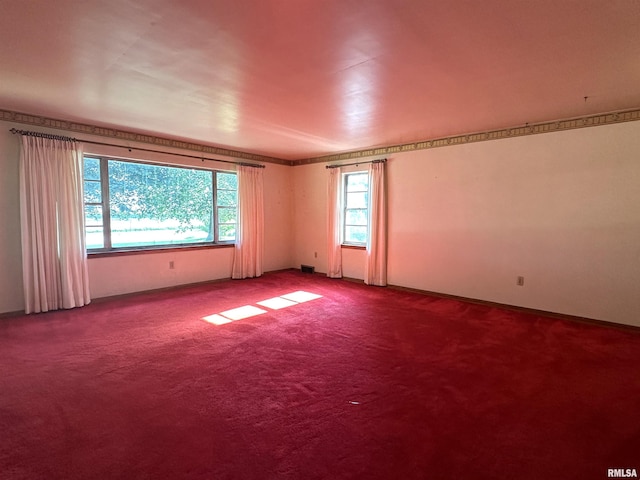 carpeted empty room with visible vents and a healthy amount of sunlight