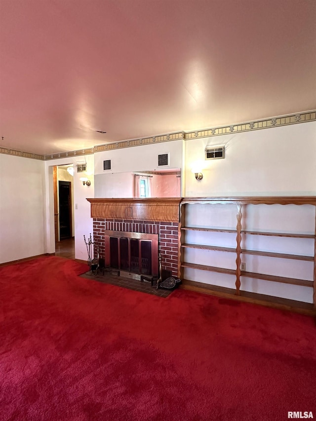 unfurnished living room with a brick fireplace, carpet flooring, and visible vents