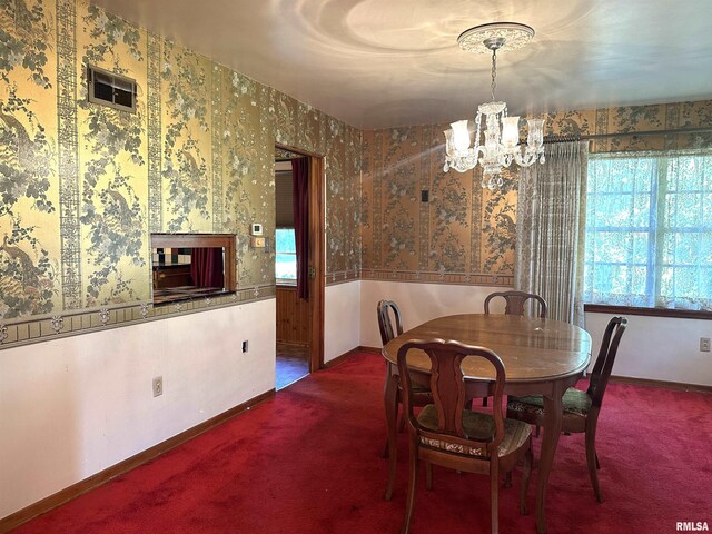 dining area with an inviting chandelier, carpet flooring, and wallpapered walls