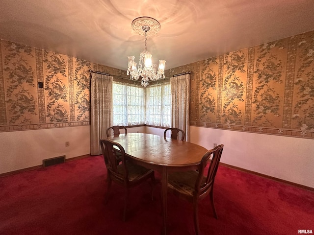 dining area featuring carpet, visible vents, an inviting chandelier, baseboards, and wallpapered walls