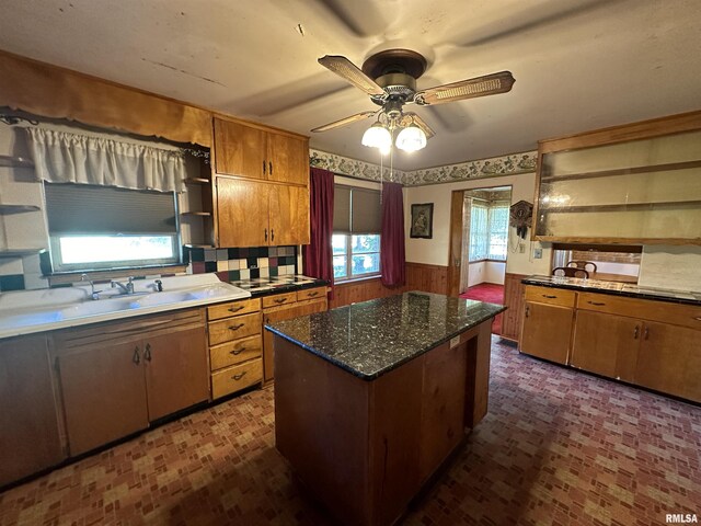 kitchen with appliances with stainless steel finishes, a center island, baseboards, and brick patterned floor