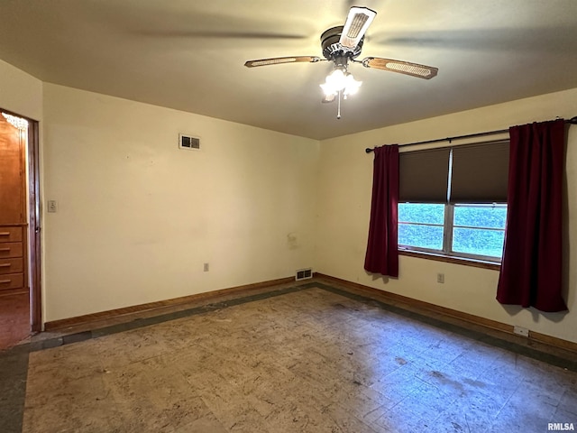 empty room featuring a ceiling fan, tile patterned floors, visible vents, and baseboards