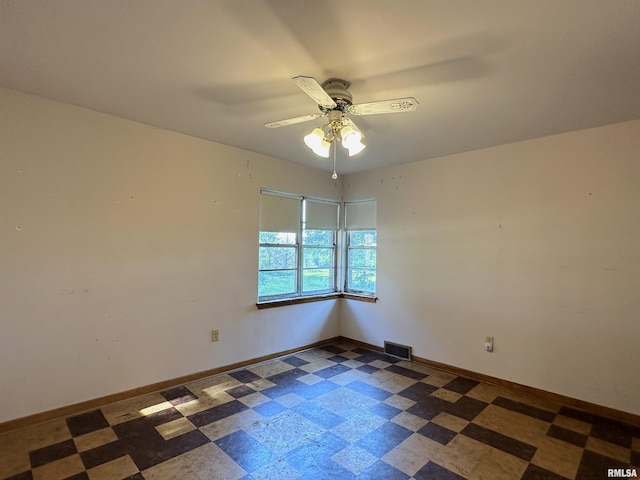 unfurnished room with tile patterned floors, visible vents, baseboards, and ceiling fan