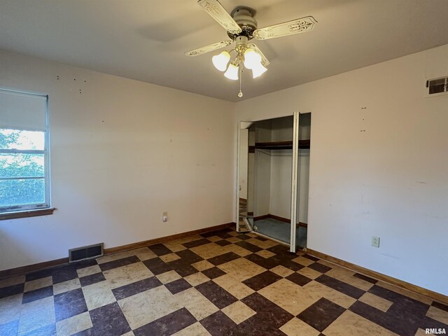 unfurnished bedroom featuring tile patterned floors, visible vents, baseboards, and a closet