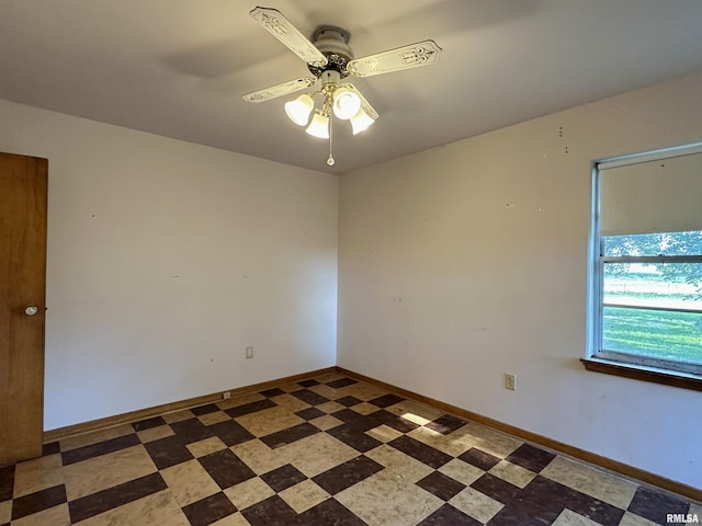 spare room featuring tile patterned floors, baseboards, and ceiling fan