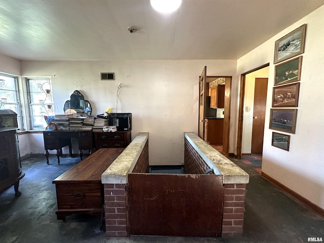interior space with baseboards, visible vents, and concrete flooring