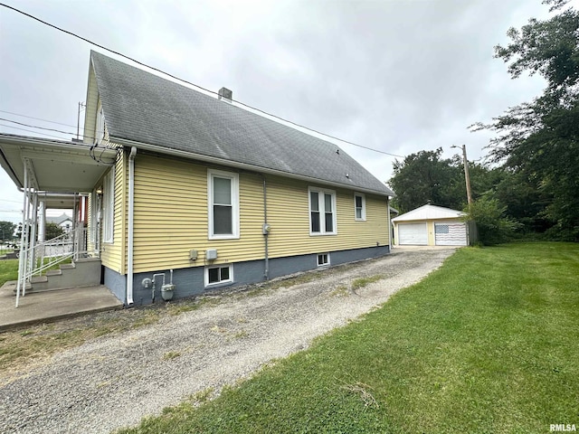 view of side of home with an outdoor structure, a garage, and a yard