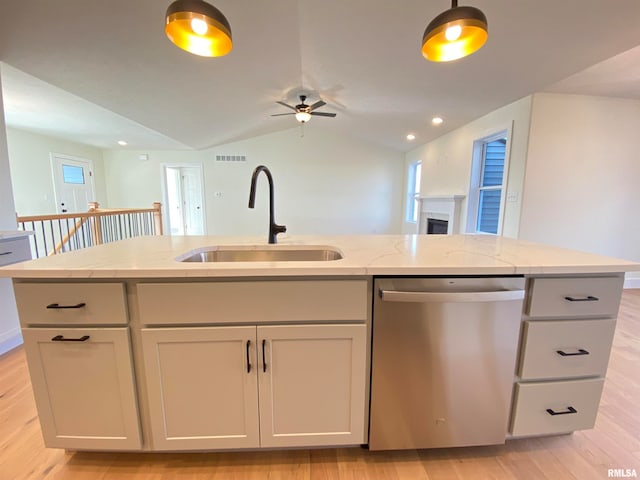 kitchen with lofted ceiling, sink, stainless steel dishwasher, an island with sink, and light hardwood / wood-style floors