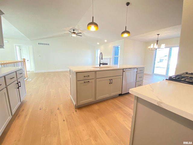 kitchen with vaulted ceiling, a kitchen island with sink, sink, dishwasher, and hanging light fixtures