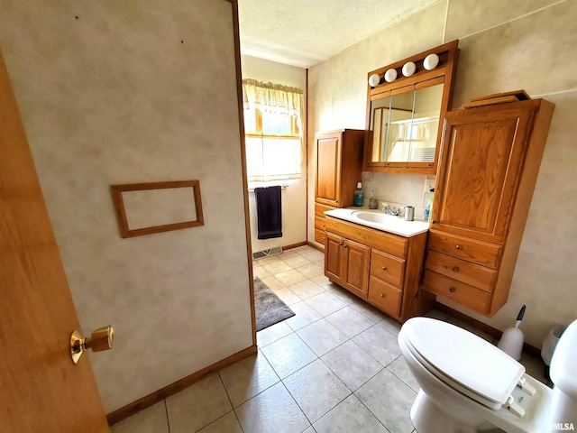 bathroom featuring vanity, toilet, a textured ceiling, and tile patterned floors