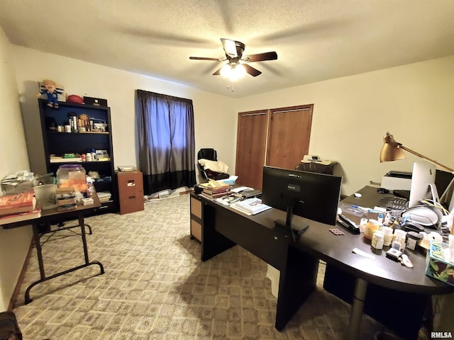 carpeted home office with ceiling fan and a textured ceiling