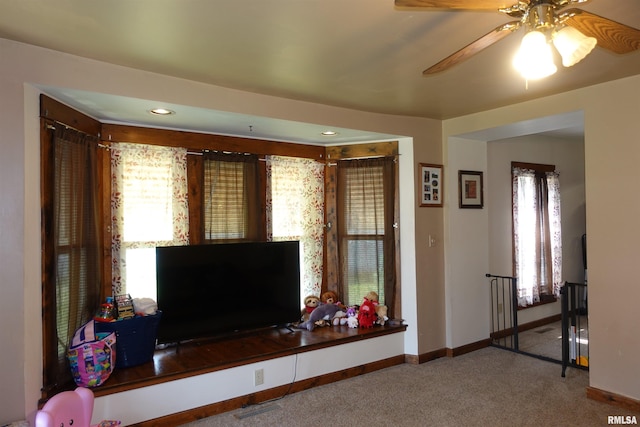 carpeted living room featuring ceiling fan