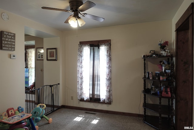 interior space with ceiling fan and carpet