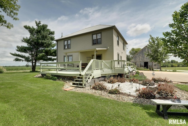 rear view of house featuring a wooden deck and a lawn